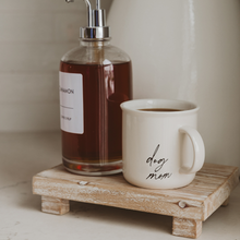 Load image into Gallery viewer, Cinnamon syrup bottle and 'dog mom' mug on a wooden stand with a neutral background
