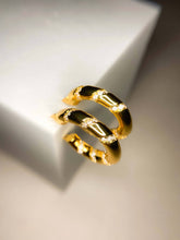 Load image into Gallery viewer, Gold hoop earrings on a light gray background
