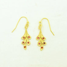 Load image into Gallery viewer, Gold earrings with red gemstones on a white background

