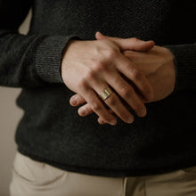 Load image into Gallery viewer, Person wearing a dark sweater with hands clasped in front
