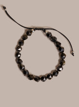 Load image into Gallery viewer, Black beaded bracelet on a beige background

