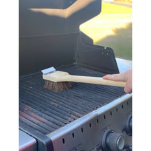Load image into Gallery viewer, Person using a grill brush on a barbecue grill
