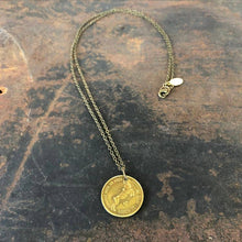 Load image into Gallery viewer, Gold necklace with a coin pendant on a textured surface
