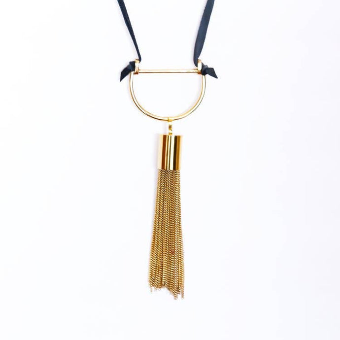 Gold tassel necklace on a white background