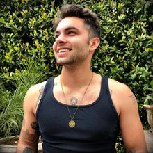 Load image into Gallery viewer, Man wearing a black tank top with tattoos, standing outdoors with greenery in the background
