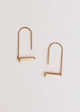 Load image into Gallery viewer, Gold earrings with a minimalist design on a light beige background
