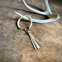 Load image into Gallery viewer, Bracelet with tassel on a textured surface with antlers in the background
