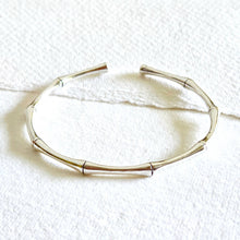 Load image into Gallery viewer, Silver bracelet on a textured white surface
