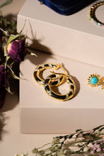 Load image into Gallery viewer, Gold hoop earrings on a beige jewelry box with flowers around
