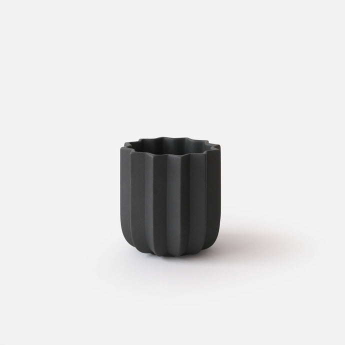 Black textured vase on a white background