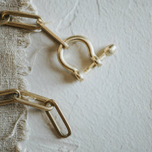 Load image into Gallery viewer, Gold chain and clasp on a textured white surface
