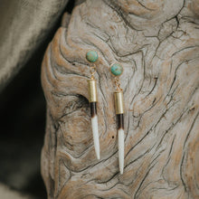 Load image into Gallery viewer, Gold earrings with turquoise stones on a textured stone surface
