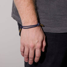 Load image into Gallery viewer, Hand wearing a blue bracelet with a gray background
