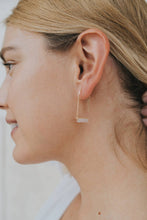 Load image into Gallery viewer, Close-up of a person wearing a gold hoop earring with a blurred background
