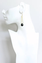 Load image into Gallery viewer, Black teardrop gold plated earring on a white mannequin ear 
