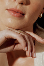Load image into Gallery viewer, Close-up of a person wearing a gold ring with a green gemstone and gold earring.
