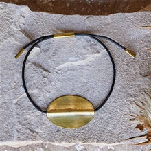 Load image into Gallery viewer, Black leather cord Bracelet with a gold pendant on a textured stone surface
