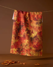 Load image into Gallery viewer, Autumn leaf patterned towel hanging on a line against a brown background
