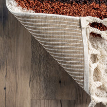 Load image into Gallery viewer, Textured area rug with fringes on a wooden floor
