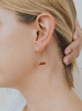 Load image into Gallery viewer, gold drop earring with a carnelian agate stone worn in a woman&#39;s ear lobe
