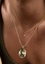 Load image into Gallery viewer, Close-up of a person wearing two gold necklaces with pendants on a skin background
