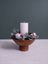 Load image into Gallery viewer, Decorative wood footed bowl candle holder with a white candle, cotton, and berries on a gray background.
