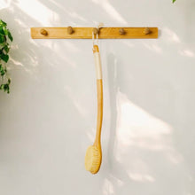 Load image into Gallery viewer, Wooden brush hanging on a wooden rack against a white wall.
