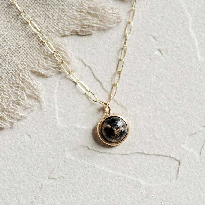 8mm copper obsidian stone set in a bezel with a thick 24K gold deposition. It is suspended from an 18-inch paperclip chain