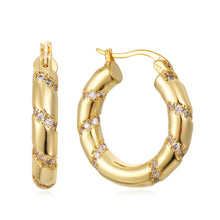Load image into Gallery viewer, Gold hoop earrings with diamond accents on a white background
