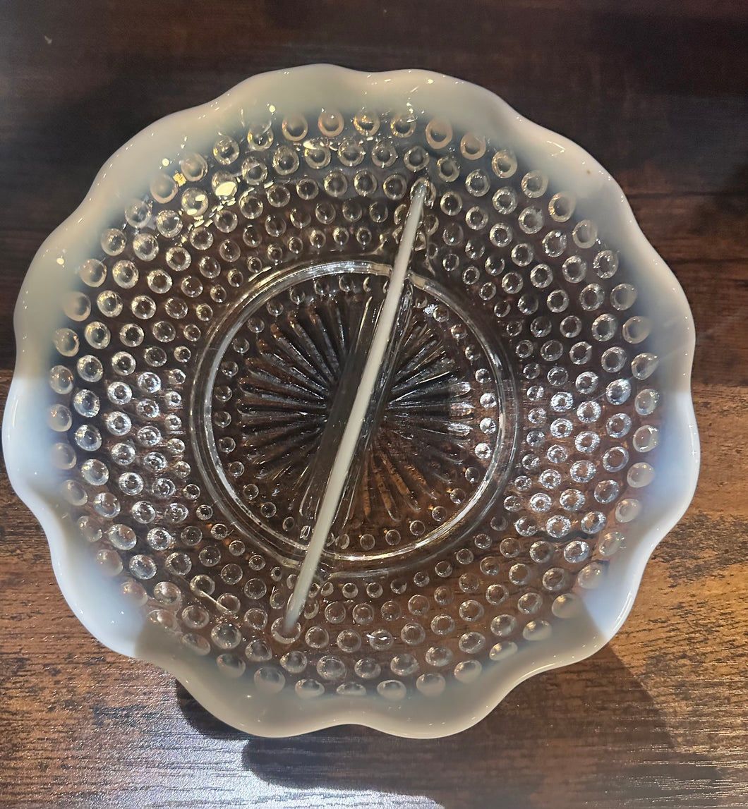 Decorative divided hobnailglass plate on a wooden surface