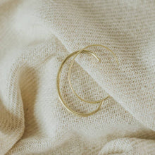 Load image into Gallery viewer, Two gold bracelets on a textured beige fabric background
