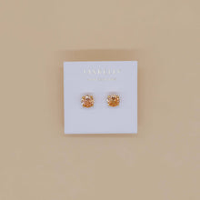 Load image into Gallery viewer, Pair of gold stud earrings on a 'JAXKELLY' branded card against a beige background
