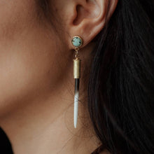 Load image into Gallery viewer, Close-up of an earring with a turquoise stone and quill on a blurred background
