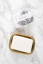 Load image into Gallery viewer, Bar of soap in a brass dish with &#39;Balsam &amp; Fir&#39; packaging on a marble surface
