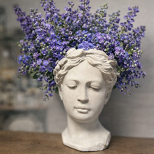 Load image into Gallery viewer, Statue head  planter with purple flowers on a wooden surface
