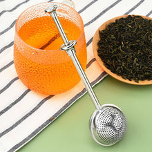 Load image into Gallery viewer, Tea infuser with a glass of tea and a bowl of tea leaves on a striped cloth.

