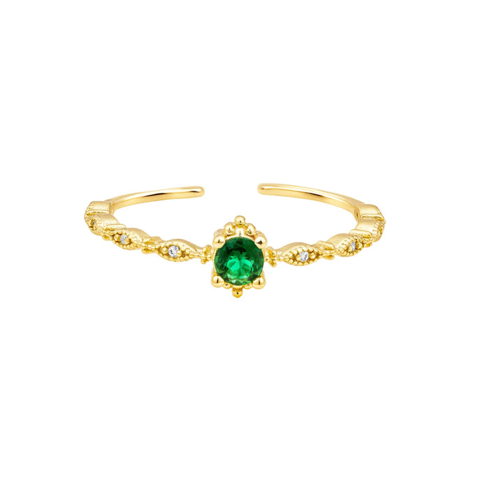 Gold ring with a green gemstone on a white background