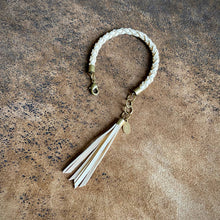 Load image into Gallery viewer, Bracelet with tassels on a textured brown surface
