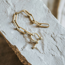 Load image into Gallery viewer, Gold bracelet on a textured stone surface
