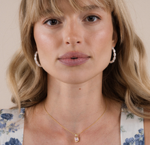 Load image into Gallery viewer, Woman wearing a gold necklace with a pink pendant against a neutral background
