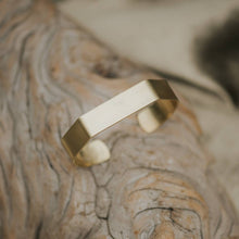 Load image into Gallery viewer, Gold bracelet on a textured surface
