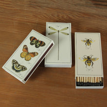 Load image into Gallery viewer, Three matchboxes with illustrations of butterflies, a dragonfly, and bees on a wooden surface.
