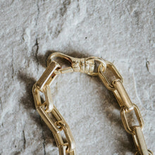 Load image into Gallery viewer, Gold chain necklace on a textured stone surface
