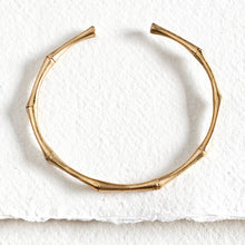Load image into Gallery viewer, Gold bracelet on a textured white surface
