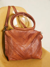 Load image into Gallery viewer, Brown leather handbag with a chevron pattern on a beige surface
