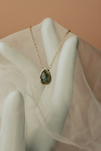 Load image into Gallery viewer, Necklace with a pendant on a mannequin hand against a beige background
