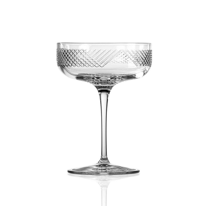 Clear glass cocktail coupe with geometric pattern on a white background