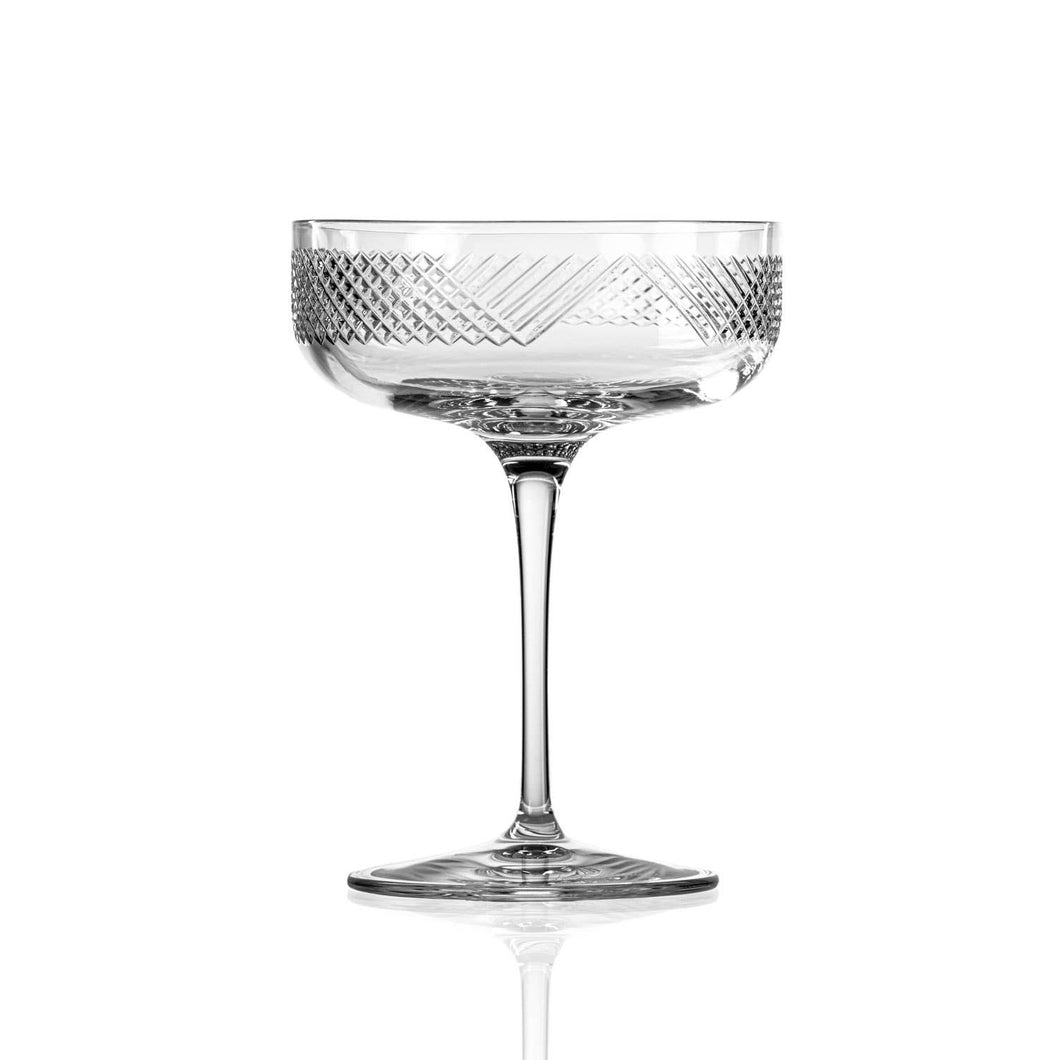 Clear glass cocktail coupe with geometric pattern on a white background