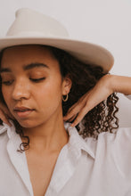 Load image into Gallery viewer, Woman wearing a beige hat and white shirt against a plain background

