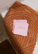 Load image into Gallery viewer, Brown towel with pink cards on a white surface
